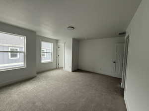 Unfurnished bedroom featuring light carpet and a textured ceiling