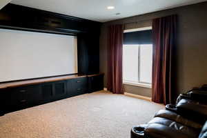 Cinema room with visible vents, baseboards, and carpet flooring