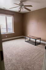 Unfurnished room featuring visible vents, carpet floors, a ceiling fan, and baseboards