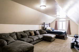 Interior space with light carpet, baseboards, and lofted ceiling