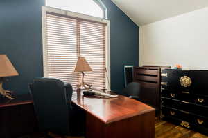 Office space featuring lofted ceiling and dark wood-type flooring