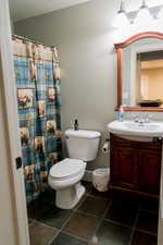 Bathroom with baseboards, vanity, and toilet