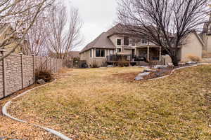 Rear view of property featuring a lawn, a fenced backyard, a wooden deck, and stucco siding