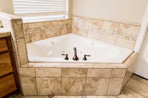 Bathroom with tile patterned flooring and a whirlpool tub