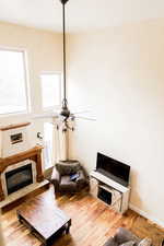 Living area with a fireplace, light wood-style flooring, and baseboards