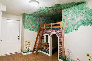 Unfurnished bedroom with a textured ceiling and wood finished floors