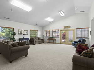 Living room featuring baseboards, visible vents, carpet flooring, french doors, and high vaulted ceiling