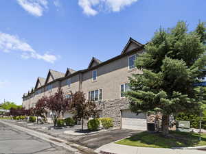 View of building exterior featuring an attached garage and aphalt driveway