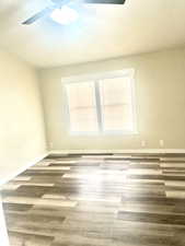 Spare room with baseboards, a ceiling fan, and wood finished floors