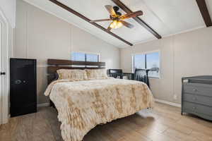 Bedroom with lofted ceiling with beams, light wood-style flooring, baseboards, and a ceiling fan