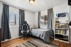 Bedroom with baseboards and wood finished floors