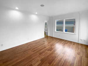 Spare room featuring crown molding, baseboards, wood finished floors, and recessed lighting