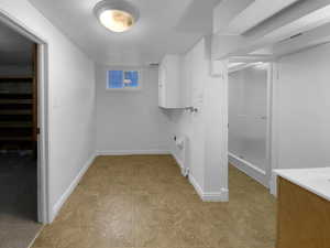 Laundry area featuring hookup for a washing machine, cabinet space, visible vents, and baseboards