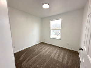 Carpeted empty room with baseboards and visible vents