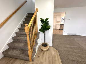 Stairs featuring baseboards, visible vents, and wood finished floors