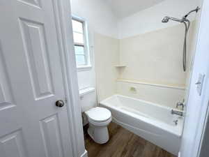 Full bath featuring toilet, wood finished floors, and shower / bathing tub combination