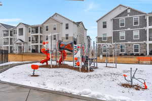 Snow covered playground featuring a residential view and a playground