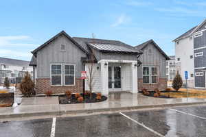 View of front of house featuring uncovered parking, french doors, board and batten siding, and brick siding