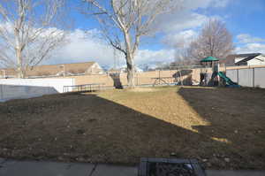 View of yard featuring a playground and a fenced backyard