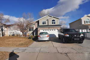 View of front of property with a garage, brick siding, and driveway