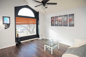 Sitting room with vaulted ceiling, dark wood-style flooring, plenty of natural light, and baseboards