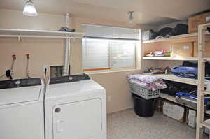 Washroom with laundry area, washing machine and clothes dryer, and light tile patterned floors