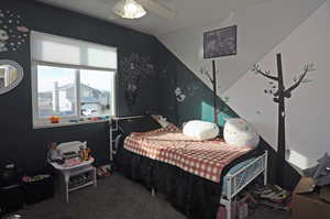 Carpeted bedroom with vaulted ceiling and a ceiling fan