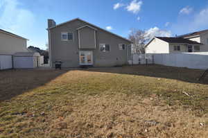 Back of property featuring french doors, a yard, a storage shed, fence, and an outdoor structure