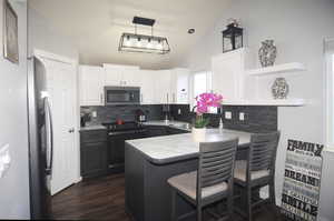 Kitchen featuring a peninsula, stainless steel appliances, white cabinetry, open shelves, and a sink