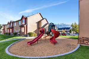 Communal playground with central air condition unit, a residential view, a mountain view, and a yard