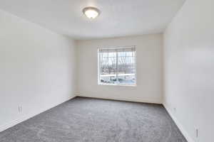 Carpeted empty room featuring baseboards