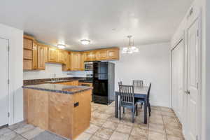 Kitchen with decorative light fixtures, visible vents, appliances with stainless steel finishes, a sink, and a peninsula