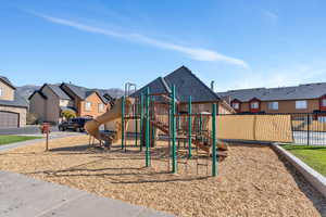 Community playground featuring fence and a residential view