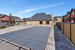 View of swimming pool featuring a residential view, fence, and a patio