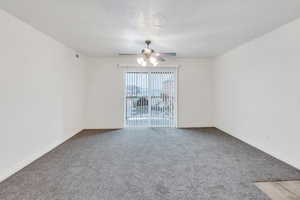 Spare room featuring light carpet, ceiling fan, and baseboards