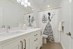 Bathroom with double vanity, tile patterned flooring, a sink