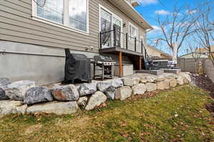 View of side of home with fence and a lawn