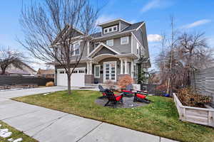 View of front facade with an attached garage, driveway, a front lawn, and fence