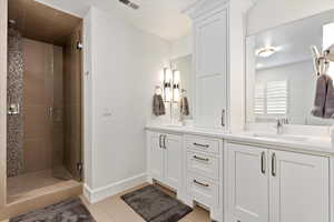 Full bathroom featuring double vanity, a sink and baseboards