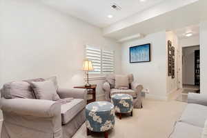 Carpeted living area featuring baseboards, and recessed lighting