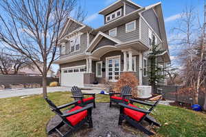 Classic 2-story home featuring concrete driveway, an attached garage, fence, a front lawn, and board and batten siding