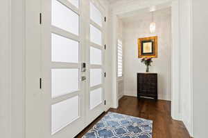 Foyer featuring dark wood-type flooring and baseboards