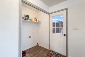 Clothes washing area with dark hardwood / wood-style floors and hookup for an electric dryer