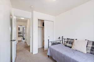 Bedroom with light carpet and a closet