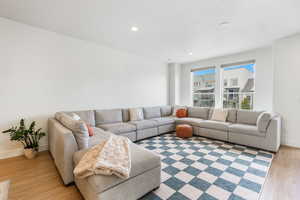 Living area featuring light wood-style floors, recessed lighting, and baseboards