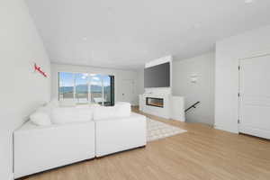 Living room featuring a glass covered fireplace, baseboards, and wood finished floors