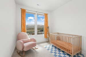 Bedroom featuring visible vents, light carpet, a mountain view, a crib, and baseboards