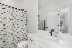 Bathroom featuring toilet, a shower with shower curtain, vanity, and visible vents