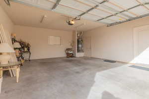 Garage featuring strapped water heater and a garage door opener