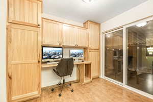 Office area with light wood-style floors and built in study area